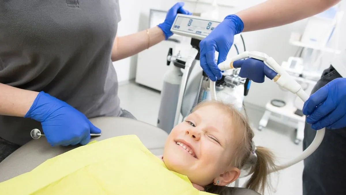 A dental provider examining a child's teeth during a routine checkup covered by family dental insurance