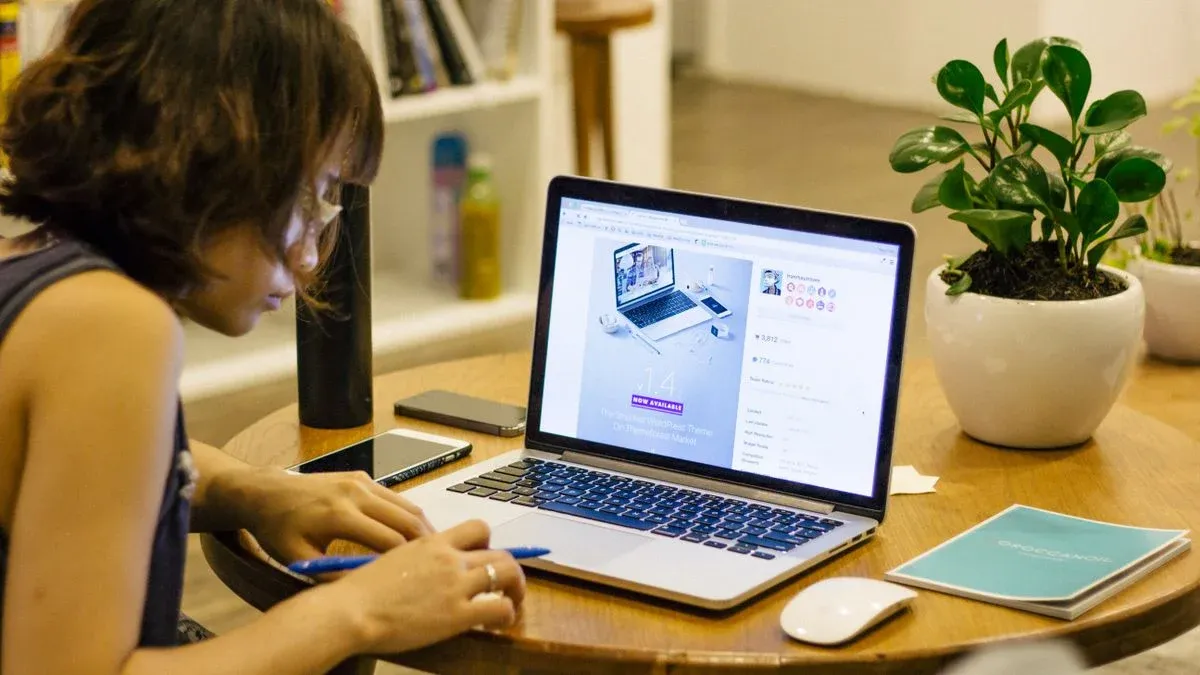 Self-employed woman working remotely on a laptop at a home desk
