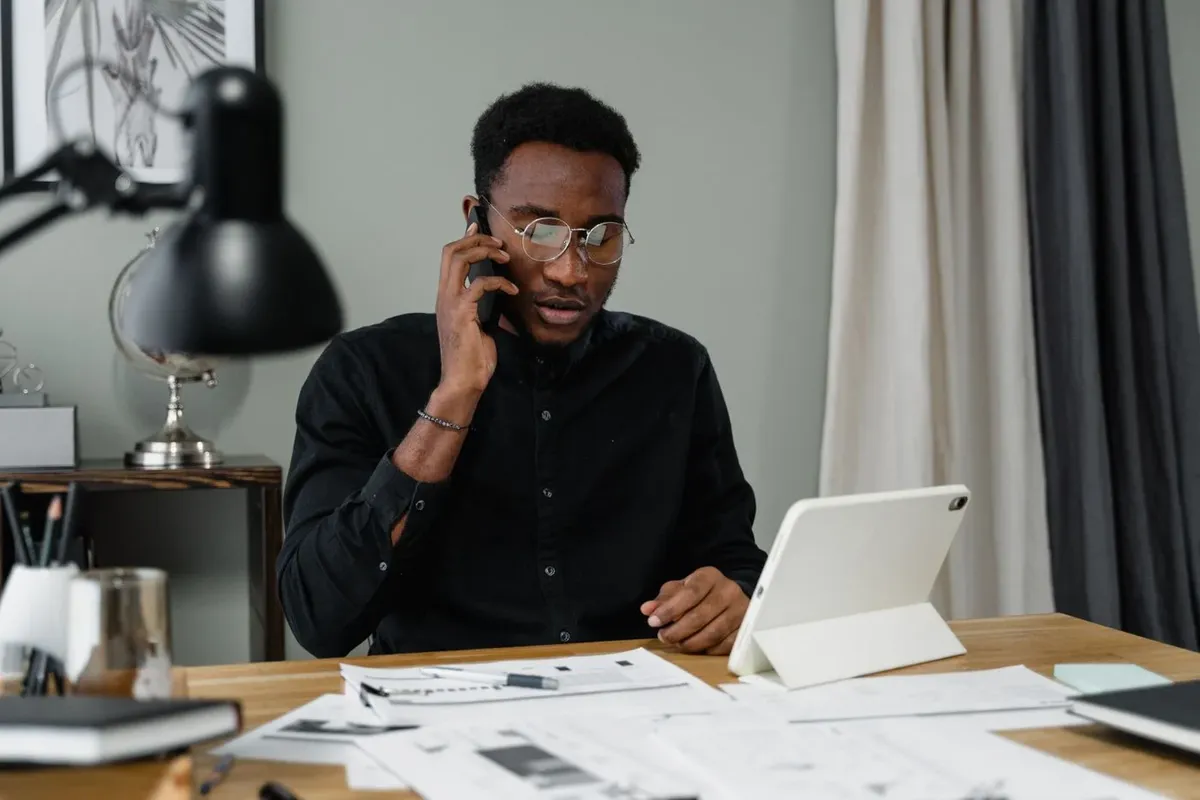 A person at a desk making a phone call while reviewing documents