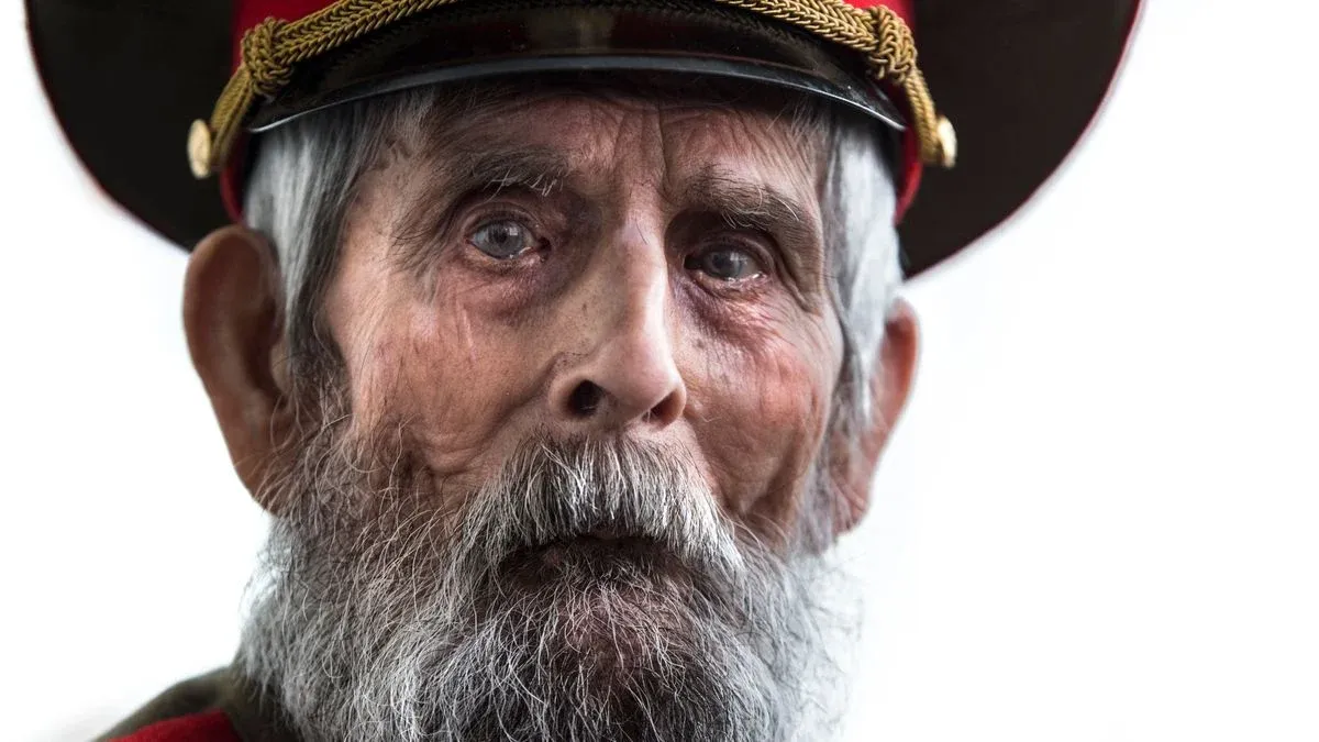 Close-up portrait of a senior military veteran wearing a uniform and cap