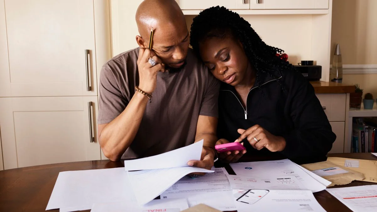 A couple sitting together calculating expenses, representing comparing dental plan annual maximums before enrolling