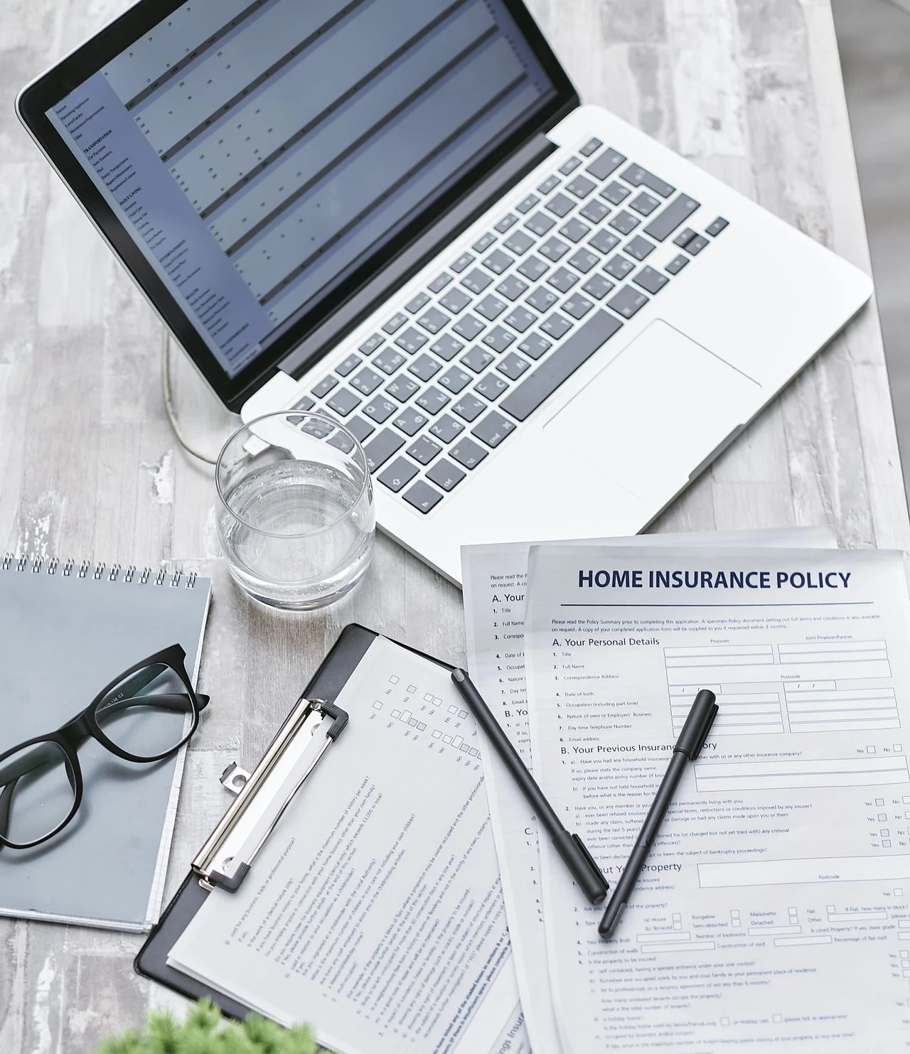 Laptop with dental insurance policy documents on desk