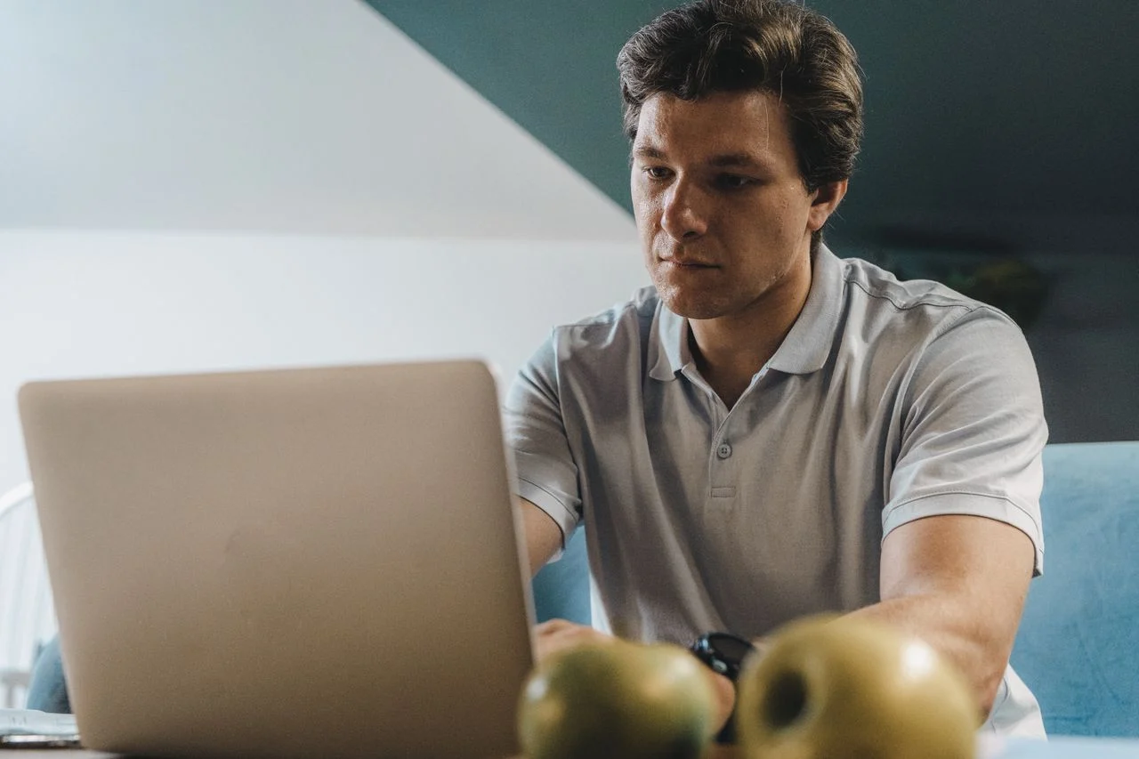 Freelancer working on laptop at home office researching dental insurance options through professional associations