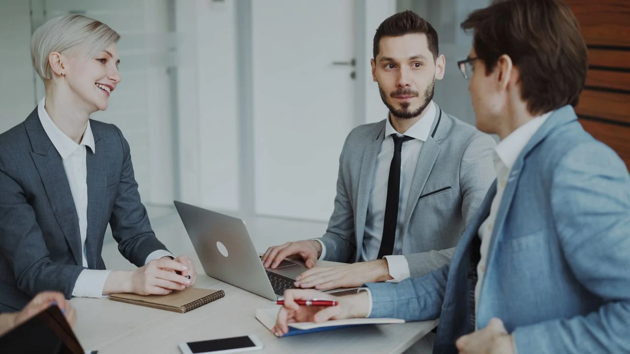 Professionals at a business association meeting discussing group dental benefits for self-employed members
