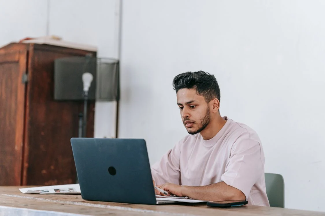 Self-employed professional comparing dental insurance plans on a laptop at a home office desk