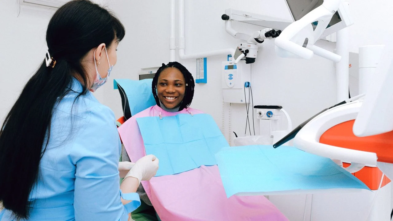 Patient smiling at dentist in a modern dental office — both Aetna and Delta Dental PPO plans cover preventive visits at 100% with no waiting period at in-network providers