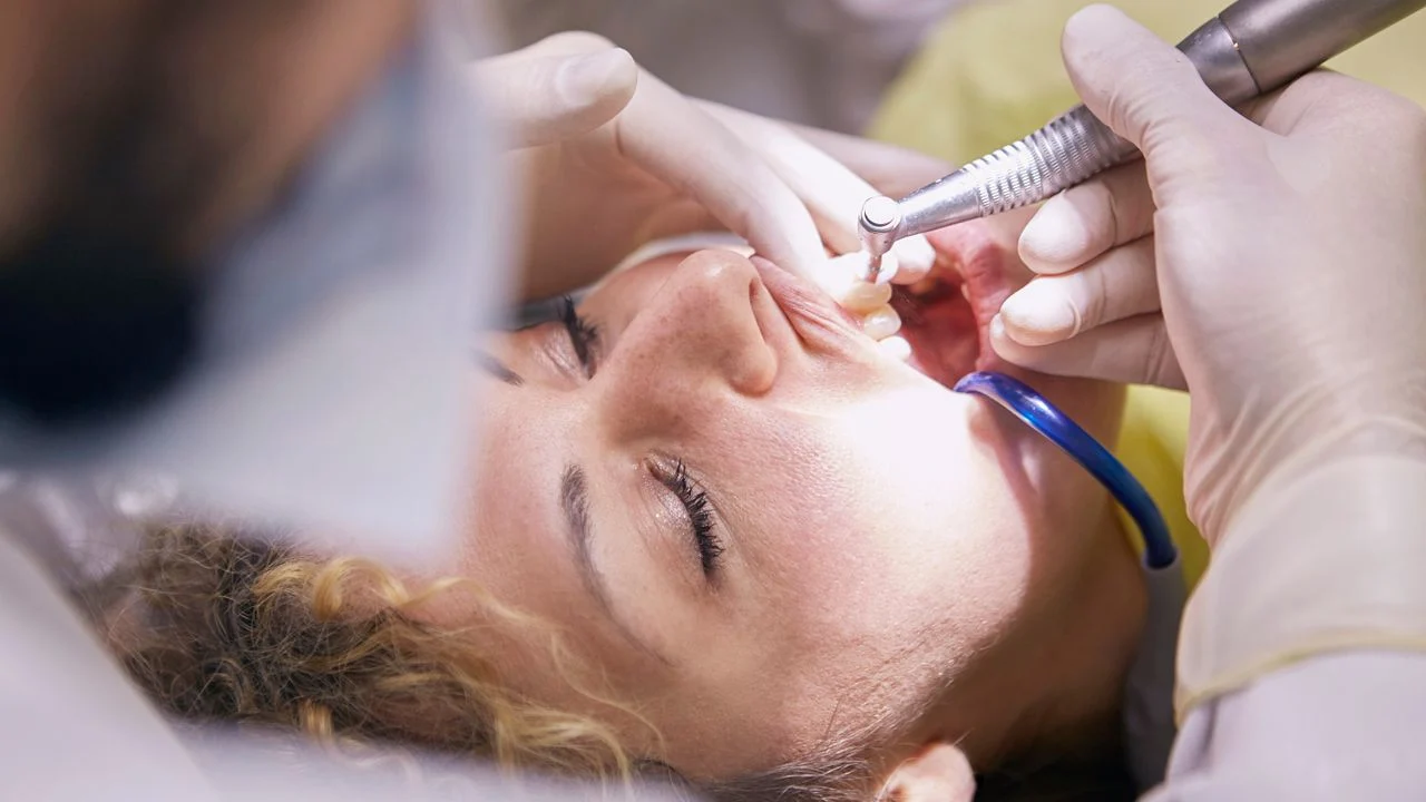 Dentist performing a dental procedure on a patient — major work like crowns and root canals frequently exceed the annual maximum benefit even on high-coverage dental plans