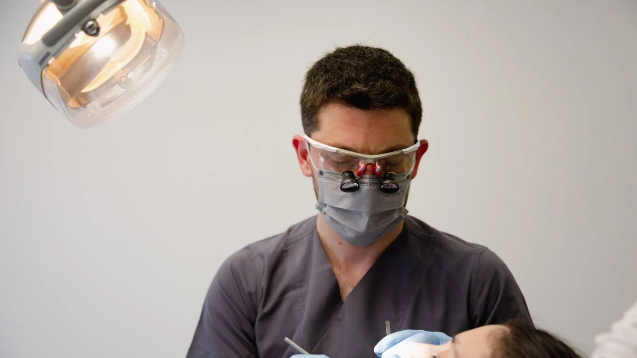 Dentist examining patient during a visit covered by individual dental insurance