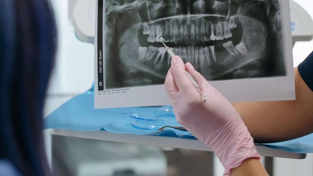 A dentist showing a dental X-ray to a patient during a consultation