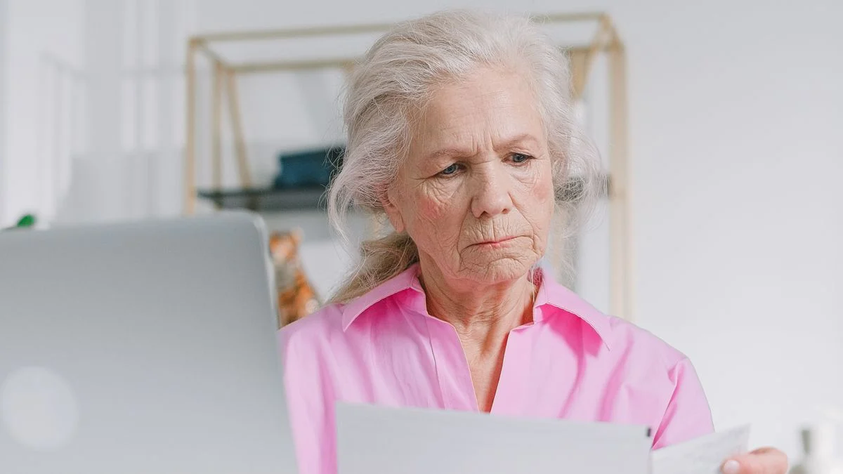 Senior reviewing dental insurance documents Older adult reviewing paperwork to understand Medicare dental coverage