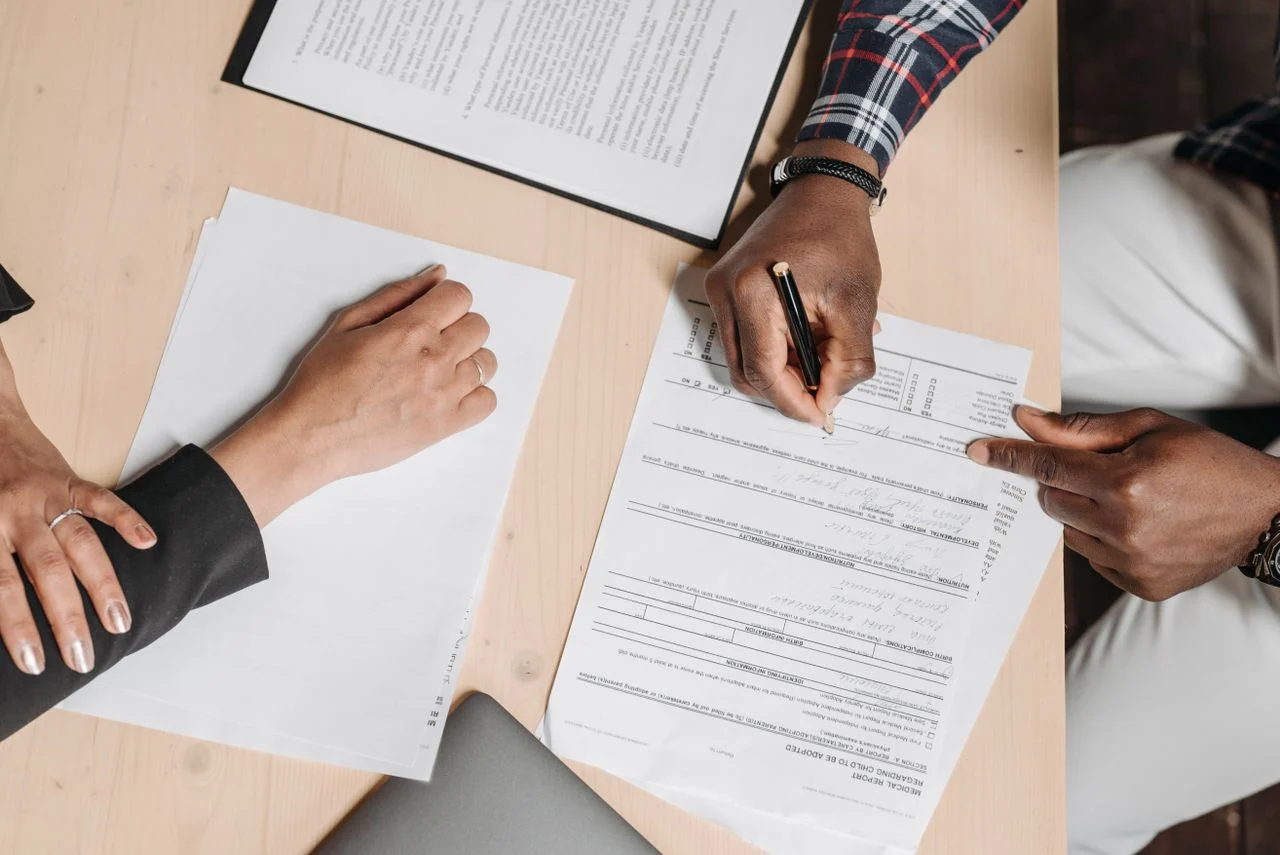 Person reviewing dental insurance documents at a desk to compare annual costs and coverage before deciding whether to buy