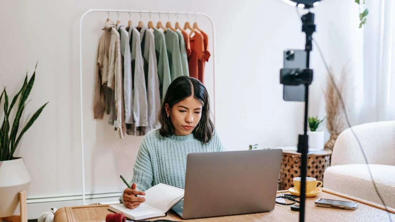 Self-employed person reviewing documents at a laptop and taking notes — comparing low-premium vs. high-coverage dental insurance options