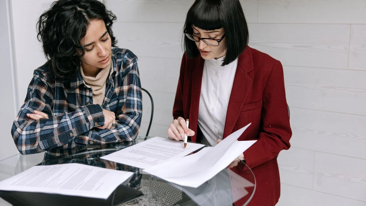 Two people at a table reviewing printed plan documents side by side while comparing dental coverage options