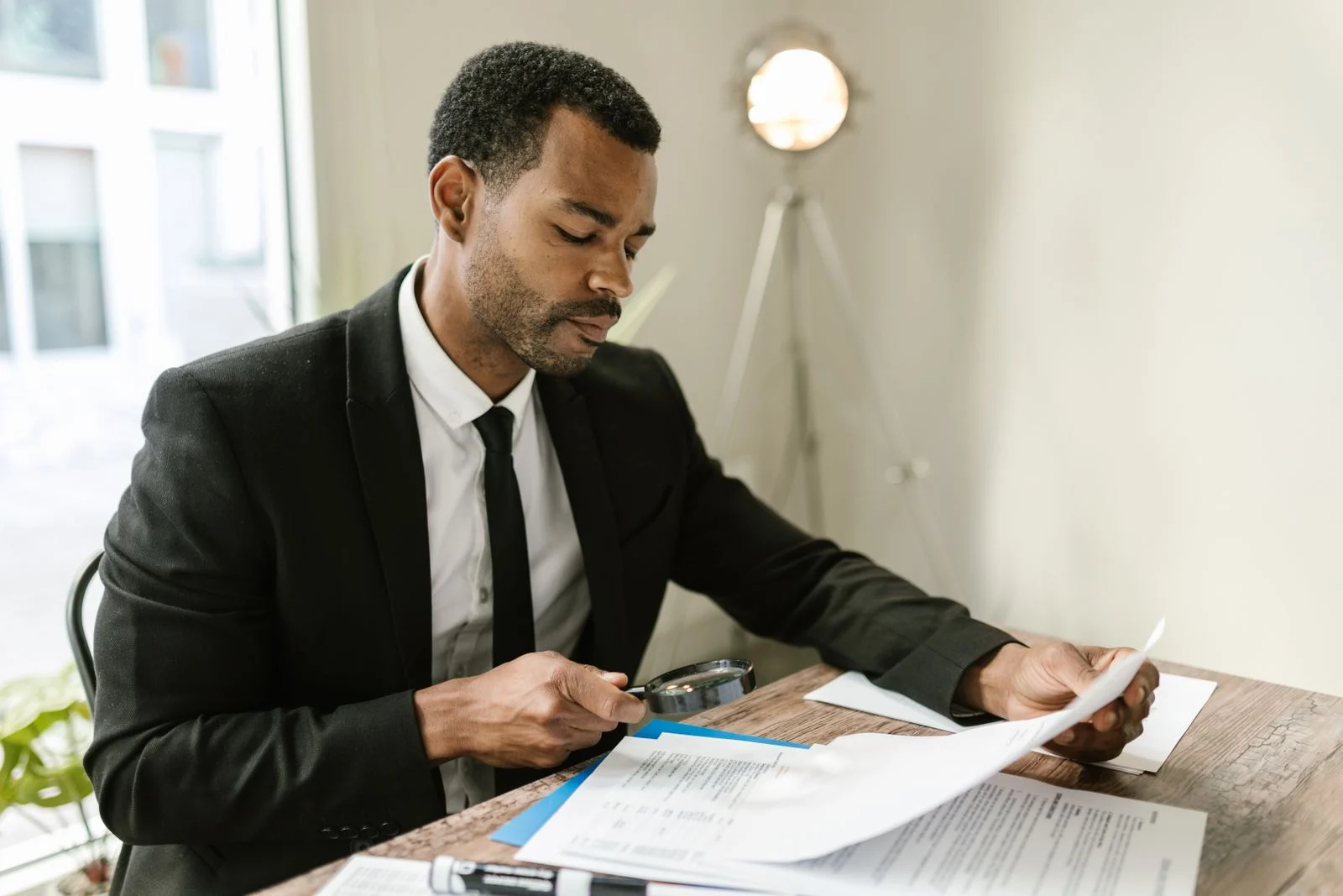 Comparing dental insurance plans side by side, reviewing the fine print Person reviewing dental insurance plan documents closely with a magnifying glass to compare the fine print