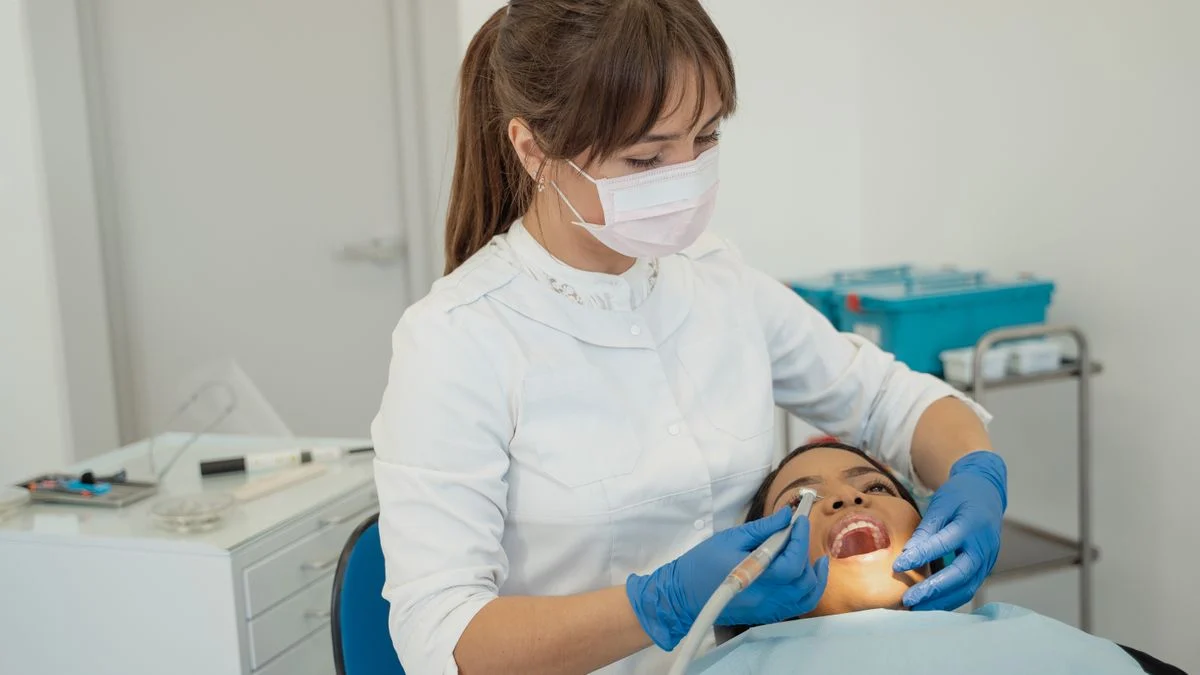 Dentist performing a routine dental check-up on a patient, the preventive care most plans genuinely cover at 100 percent