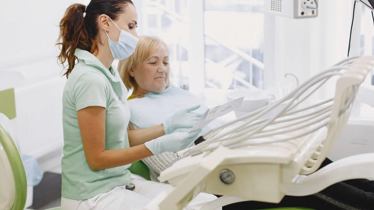 Dentist discussing coverage options with a senior patient Dentist explaining dental care options to an older woman in a modern clinic, illustrating how seniors weigh MetLife plan choices