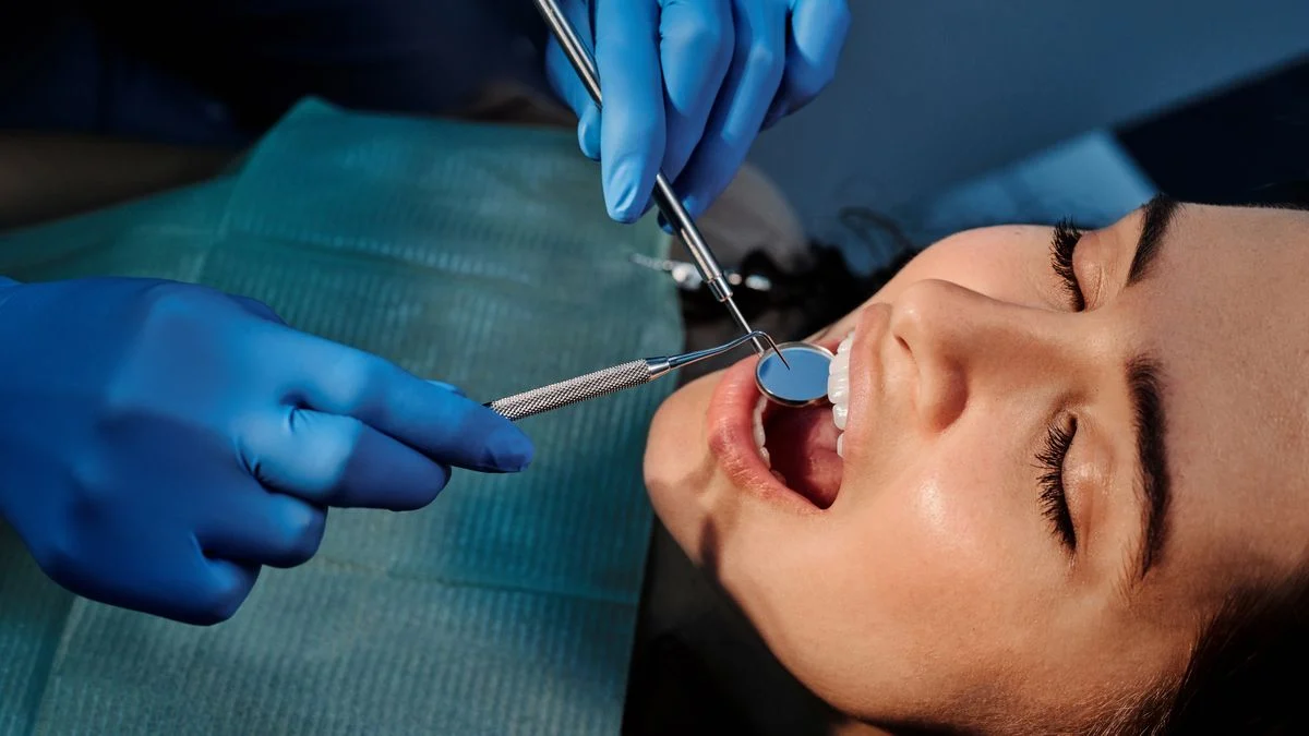 Close-up of a dentist examining a patient teeth using dental tools during an assessment
