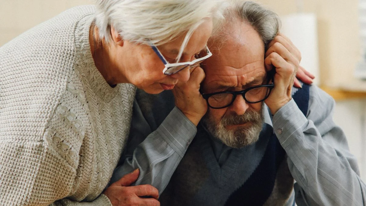 Senior couple reviewing dental insurance plan documents A worried senior couple reviews important dental insurance documents at their kitchen table.