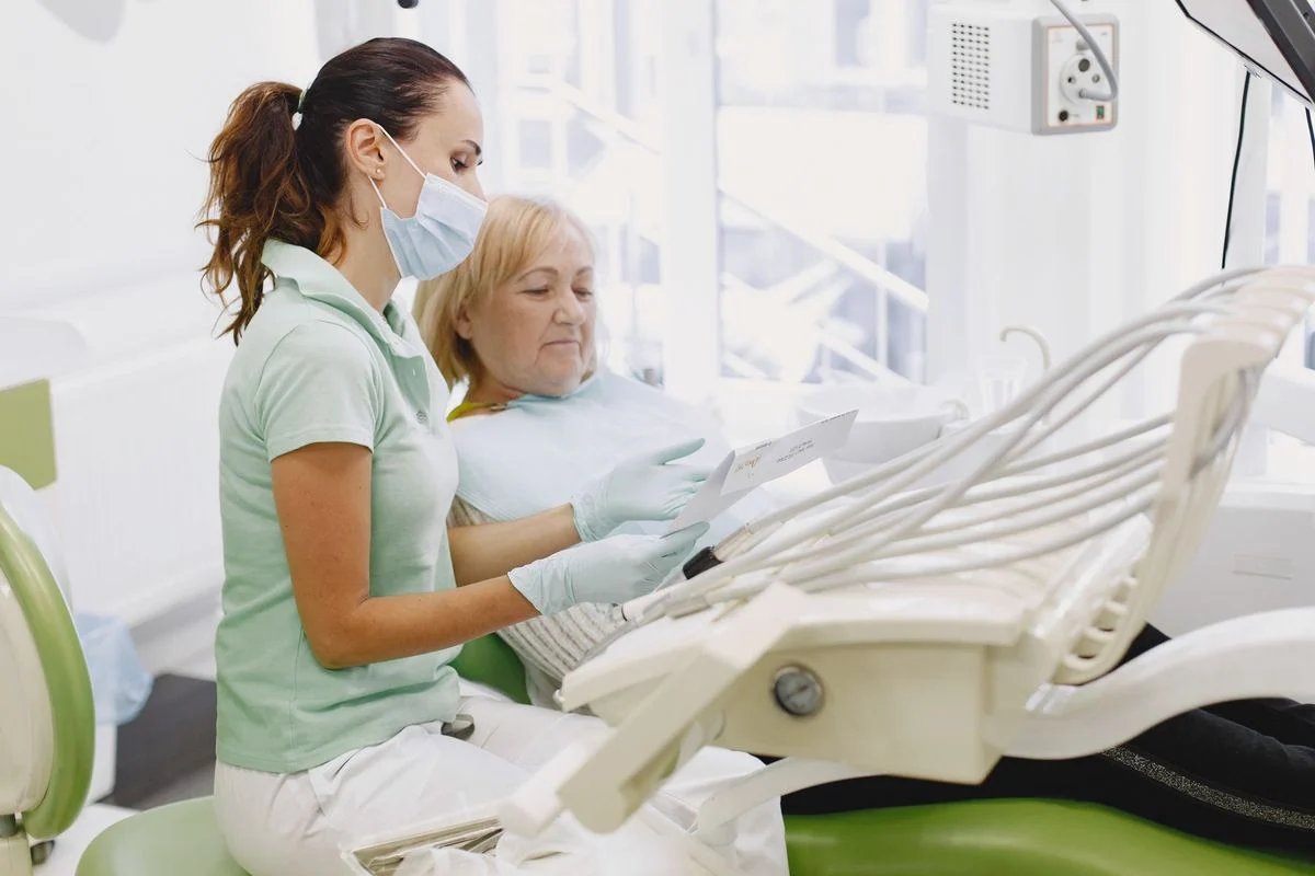 Dentist reviewing treatment plan with senior patient A female dentist reviews a treatment plan with a senior patient in a dental clinic.