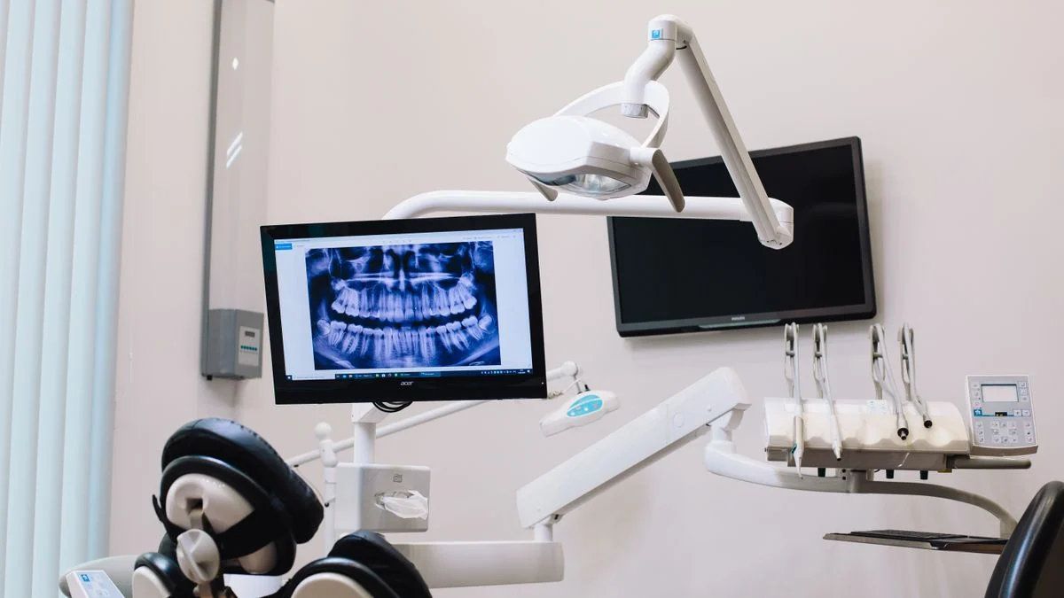 Modern dental office with a digital X-ray displayed on a monitor beside advanced treatment equipment