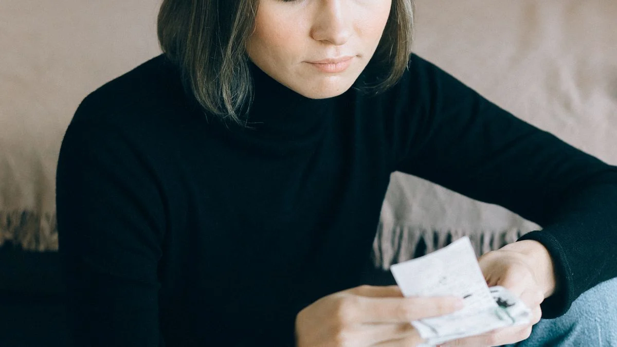 Person reviewing bills and using a calculator at home, comparing dental insurance premiums and out-of-pocket costs