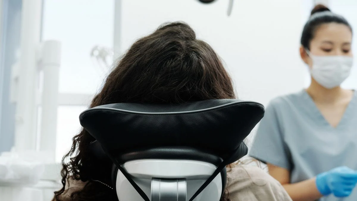Patient seated in a modern dental chair during a checkup, illustrating the waiting period before major work is covered