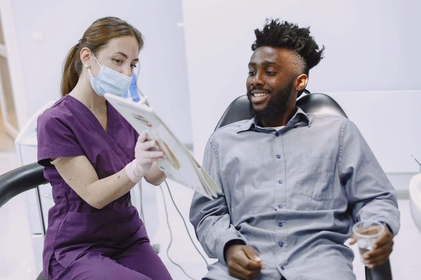 Dentist explaining a treatment plan to a patient A dentist explaining a treatment plan to a patient, showing how the term on paperwork differs from everyday language